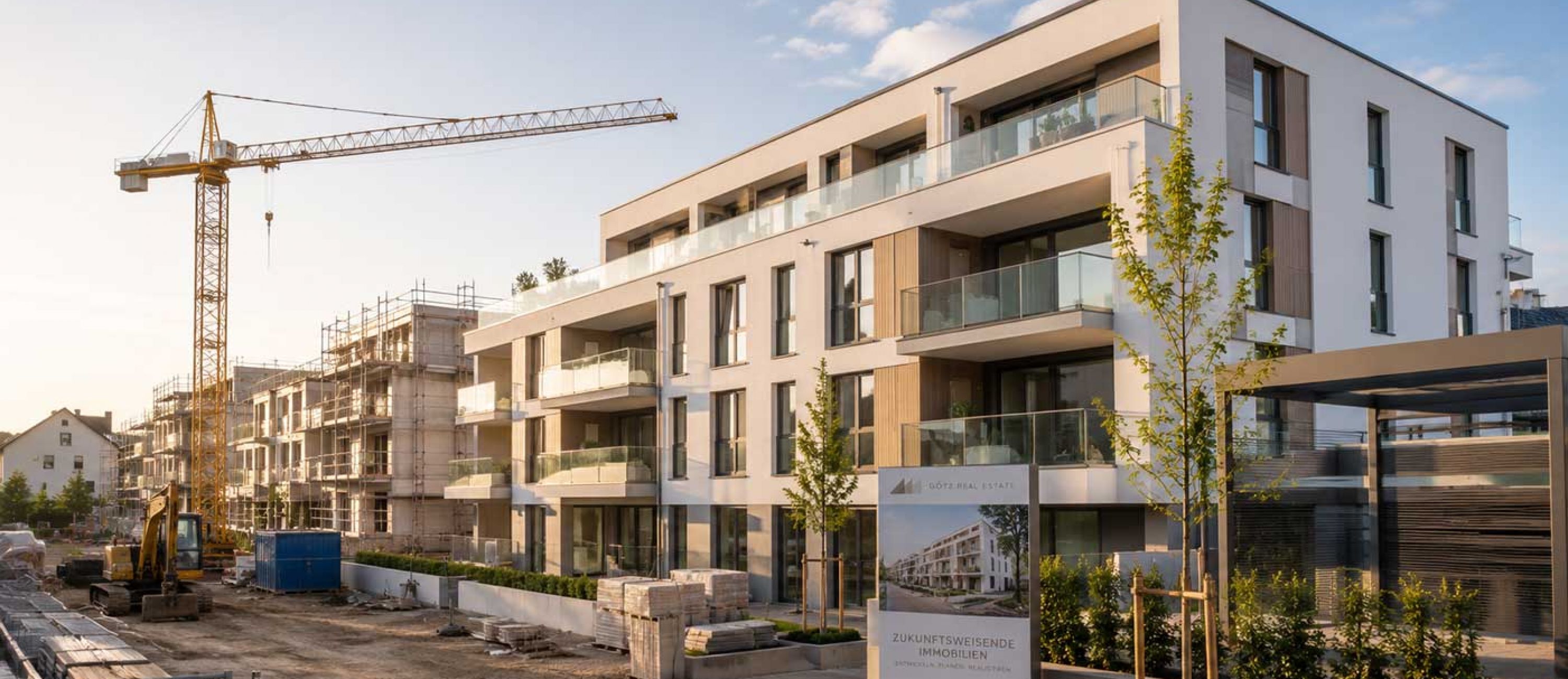 Götz Real Estate, Moderne Wohnanlage im Bau bei Sonnenuntergang
